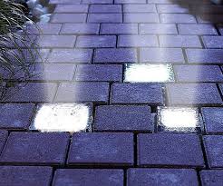 Solar-powered LED paver lights embedded in a pathway, providing illumination and aesthetic appeal.